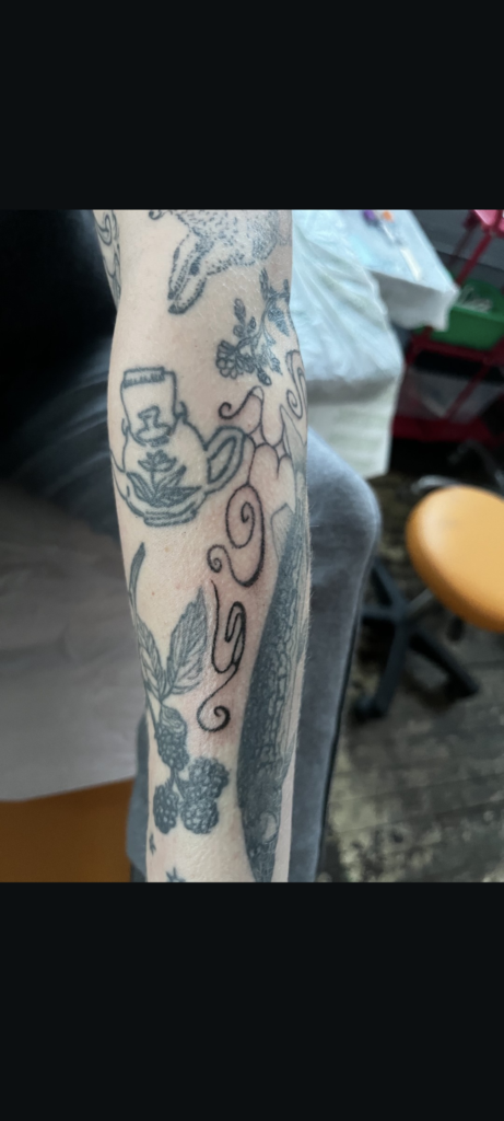 Swirling lines in between other tattoos 