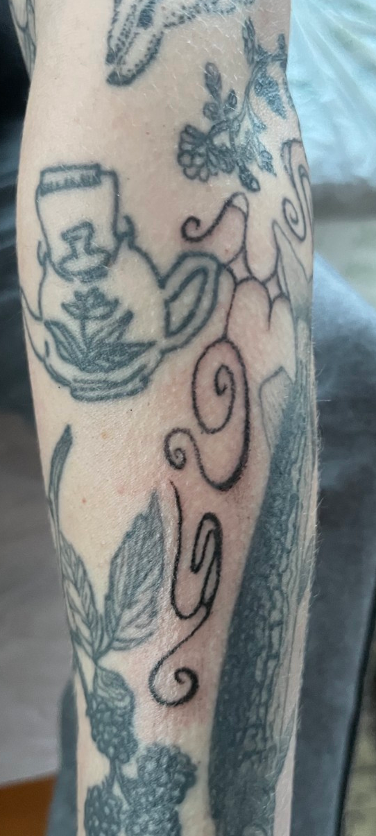 Swirling lines in between other tattoos 